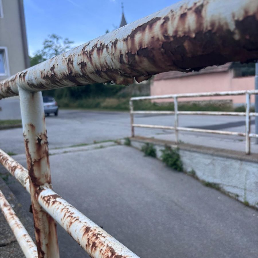 Zhrdzavené kovové zábradlie pred renováciou